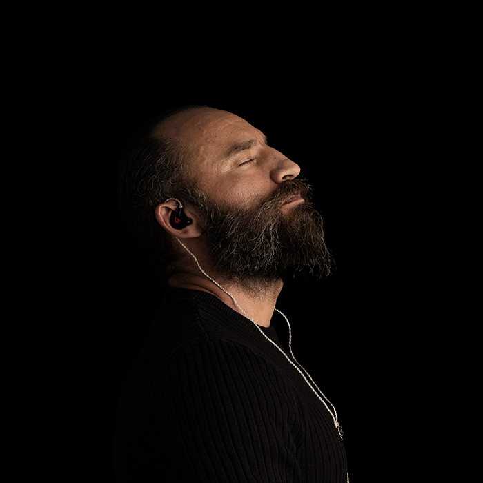 Man music lover with his eyes closed, completely absorbed in listening to his favourite music while using Clariden iem for an exceptional sound experience.