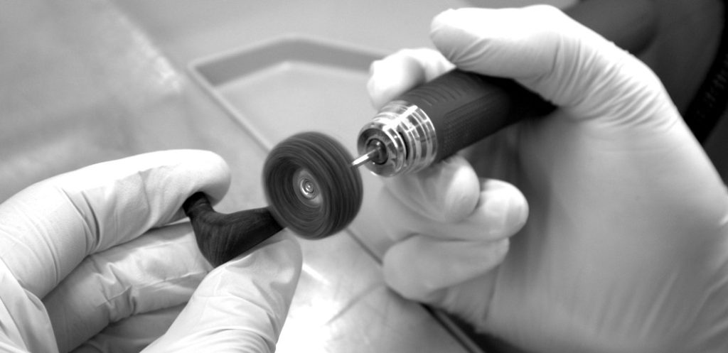 Close-up of manual finishing work on the body of Todi in-ear monitors, showcasing detailed craftsmanship and quality control.