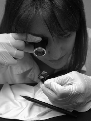 Laboratory technician examining the workmanship of a Todi device with a magnifying glass. Image emphasizing the detailed quality assessment process to guarantee accuracy and superior standards in Todi products.