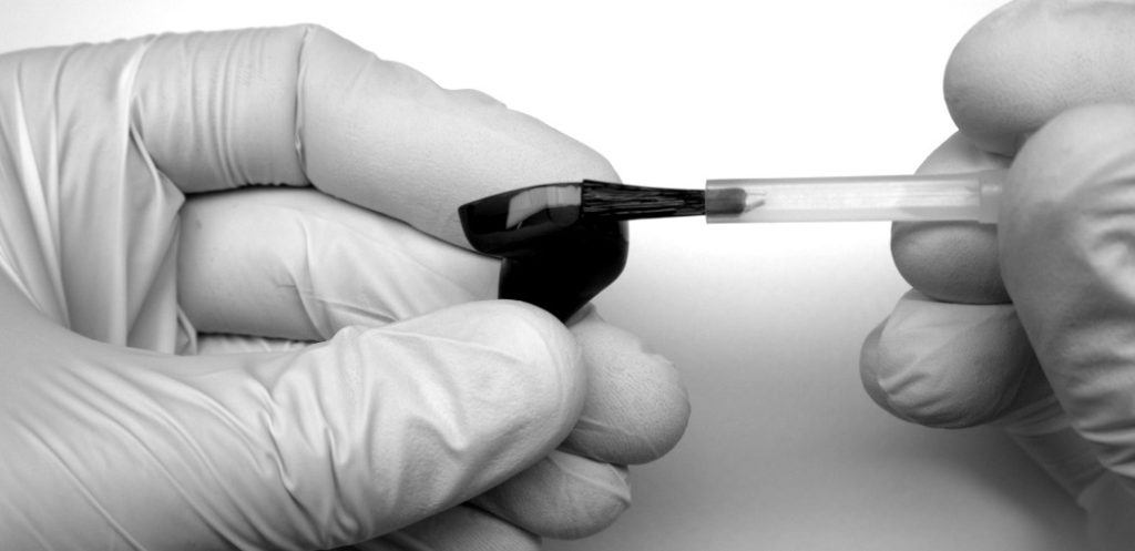 Varnishing process with a brush on a Todi device body. Image highlighting the meticulous application of varnish to achieve a premium finish on Todi products.