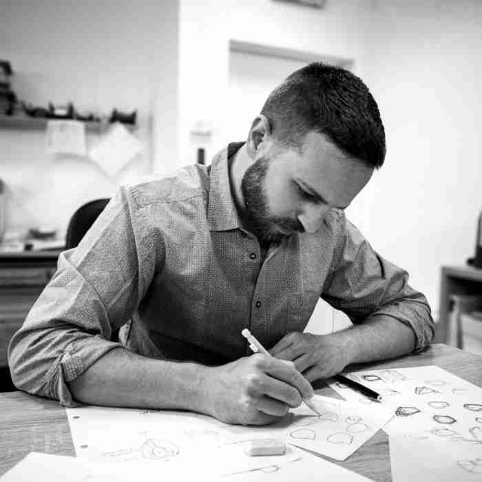 Image of a designer at work, with design concept sketches for a new product over the table.